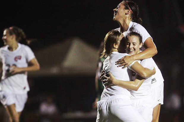 Mallory Outerbridge, left, and Sydney Sisler, top, hug Christen Sims after Sims netted the go-ahead goal against North Texas. The Lady Toppers won by a 1-0 score.