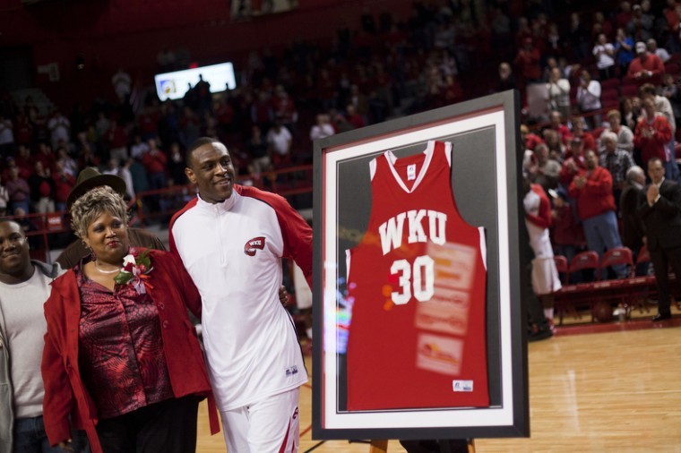 Senior forward Steffphon Pettigrew smiles with his family as he walks past his jersey, framed at midcourt during Thursdays Senior Night in Diddle Arena. 