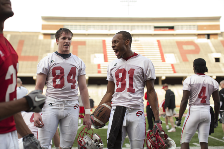 Sophomore wide receiver Jamarielle Brown (right) shares a moment with sophomore tight end Jim Murphree and other teammates during a water break in the Toppers Monday afternoon spring practice.