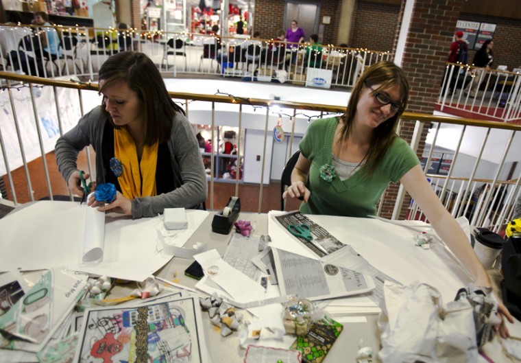 Senior Morgan Mickelson, left, of Lexington, and Sarah Ferguson,
WKUs Recycling and Surplus Coordinator, demonstrate upcycling at
their recycled gift wrapping table. WKU Fair Trade hosted an Fair
Trading Post in the third floor mezzanine of Downing University
Center on Wednesday, Dec. 14, 2011.
