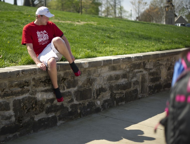 Union County sophomore Coleman West adjusts his high heels Wednesday during the Interfraternity Councils Walk a Mile in Her Shoes event. Members of several fraternities put on high heels and walked around campus to raise money for gender-violence awareness.

