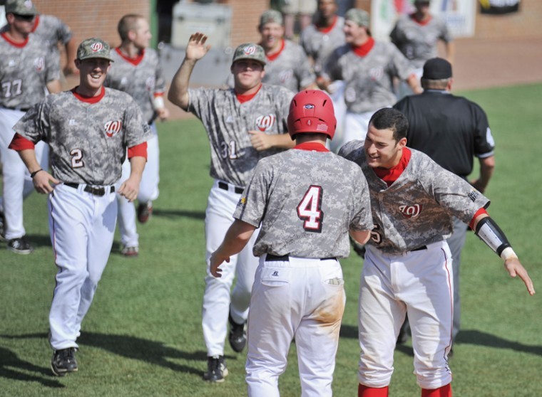 Senior outfielder Jared Andreoli is congratulated by junior catcher Devin Kelly and teammates after scoring the winning run off a walk in the bottom of the 11th inning Saturday at Nick Denes Field. WKU beat Louisiana-Monroe 7-6 for their lone win in the three-game weekend series.

