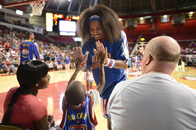 Moose Weekes gives Khalil Smith, 5, a high five during the Harlem Globetrotters performance at Diddle Arena on Monday, Jan. 14.
