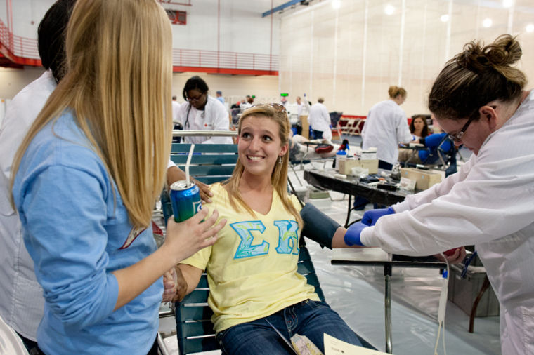 Lexington freshman Madelyn Culbertson looks to Bowling Green freshman Audrey Brown for comfort while Nashville Red Cross professional phlebotomist Laura Hartsock prepares her arm to donate blood.
