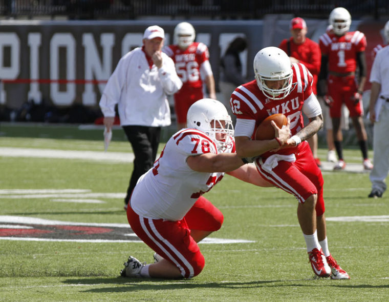 Sophomore defensive lineman Steven Caudill tackles junior quarterback Brandon Doughty during the 2013 spring football game. The Red Team defeated the White Team 42-3 on Saturday.
