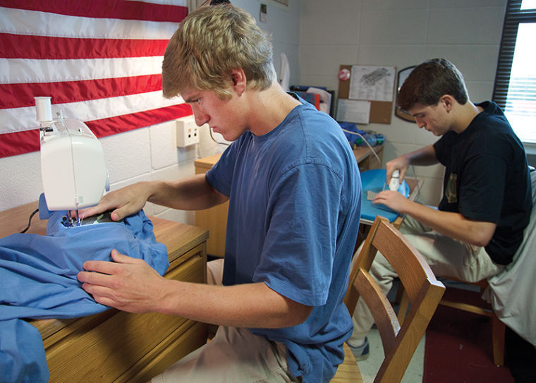 Freshman Davis Church sews on shirt pockets as Freshman Trent Erps irons the next pocket in their dorm room. The two long time friends started their business Helm Brothers at the beginning of the fall semester at WKU. The business consists of sewing on custom shirt pockets onto t-shirts. They are both brothers in Phi Gamma Delta Fraternity.