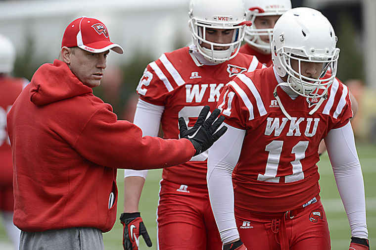 WKU Offensive Coordinator Jeff Brohm holds tight end Devin Scott during a drill at WKU football teams first spring practice on March 22, 2013. Brandon Carter/Herald