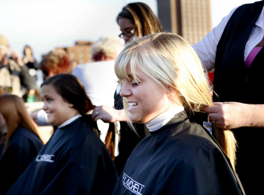 Bardstown junior Lauren Osbourne readies herself for the Paul Mitchell beauticians scissors to glide through her hair. Osbourne, a cancer survivor herself and mentor for girls with cancer, donated inches of hair during the fifth annual Saint Baldricks head shaving event at Nick Deans Field on Saturday. (Tyler Essary/HERALD)
