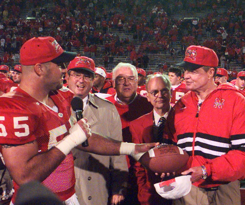 Jason Peter hands Tom Osborne the game ball after the Huskers gave the coach his 250th victory at Nebraska with a 69-7 trouncing of archrival Oklahoma on Nov. 1, 1997.