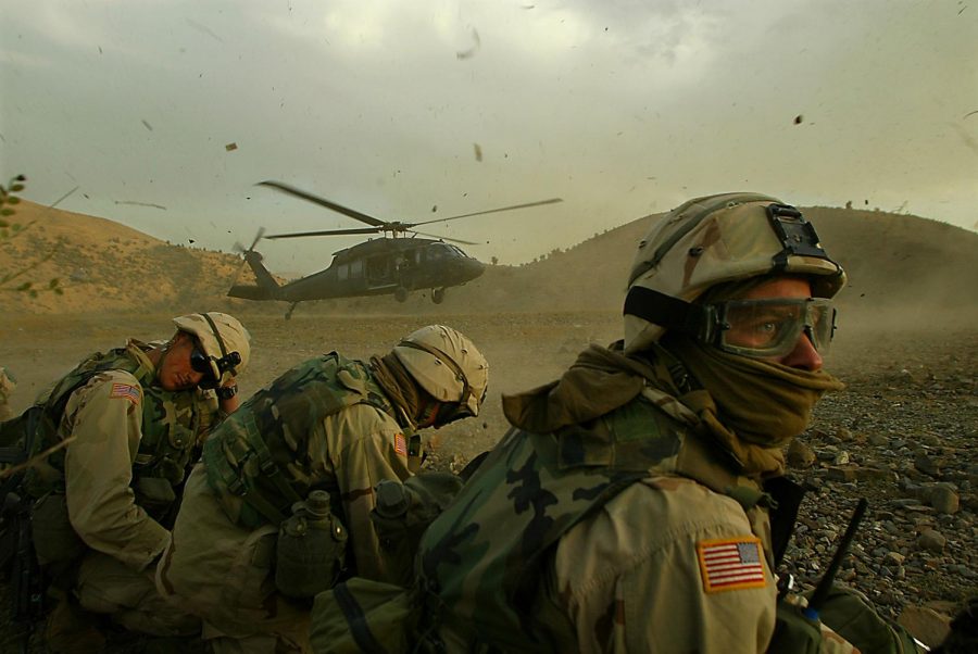 Members of the 82nd Airborne duck away from the debris being thrown into the air as a Blackhawk helicopter prepares to exfil soldiers on a mission searching remote villages in southeastern Afghanistan.