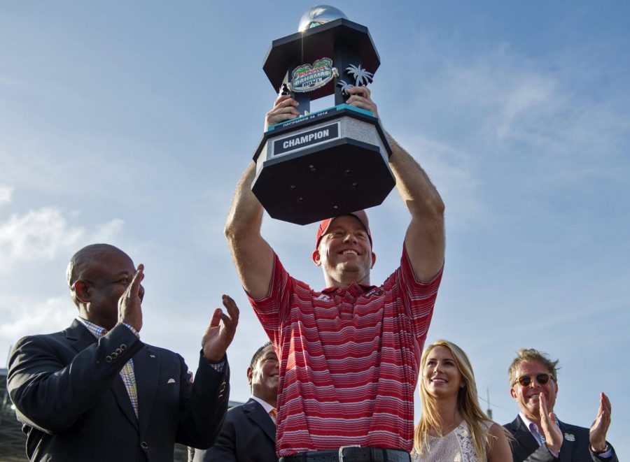WKU Head Coach Jeff Brohm hoists the championship trophy above his head, following the Hilltoppers 49-48 win over Central Michigan in the Popeyes Bahamas Bowl game in Nassau, on Wednesday, Dec. 24, 2014. Nick Wagner/HERALD