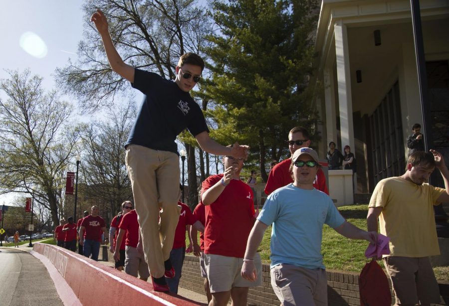 Hebron, Ky. senior Connor Snyder balances on a traffic barrier along Normal St. during Walk A Mile in Her Shoes Tuesday, March 31, 2015, in Bowling Green, Ky. 'I want to say it's fun but I'm a little sore afterwards,' Snyder says. Walk A Mile is an annual event in which male WKU students walk from Centennial Mall to Cherry Hall and back in order to raise awareness about sexual assault. Mike Clark/HERALD