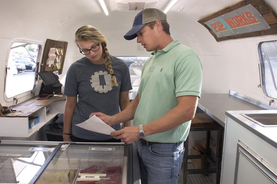 Ed Griffin of Tuscaloosa, Ala., owner of Griff’s Deli and PopWorks, discusses popsicle flavors with employee Cassady Puckett of Bowling Green. Over 700 popsicles are made daily using Micah Griffins homemade recipes. 