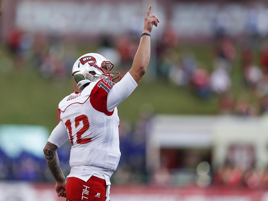 Western Kentucky quarterback Brandon Doughty (12) points upwards after a touchdown is scored in the first half to make it during a NCAA game at Memorial Field, in Bloomington, Ind., Sept. 19. Michael Noble Jr./HERALD