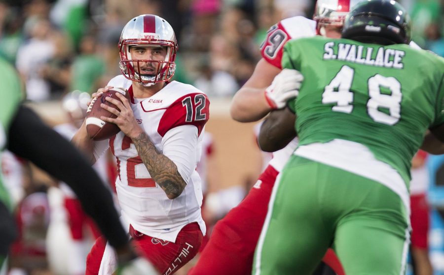 WKU quarterback Brandon Doughty (12) looks for an open receiver after the snap during the game against North North Texas at Apogee Stadium, Oct. 15. Doughty finished the game with 350 passing yards with four touchdowns and one interception. Colin Mitchell/North Texas Daily