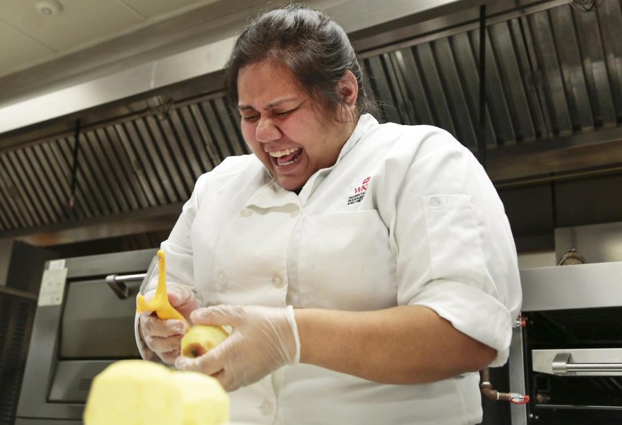 Louisville senior Gabby Hermosillo laughs at her classmates joke while preparing apples for Thursdays student-led dining experience, a South African-inspired meal, in the Micatrotto Dining Room in the Academic Complex. Leanora Benkato/HERALD