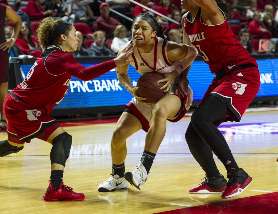 WKUs forward Taylor Brown (2) drives to the hoop in between Louisville guard Briahanna Jackson (23) and forward Cortnee Walton (13) during the Lady Toppers 71-69 win Saturday at E.A. Diddle Arena.