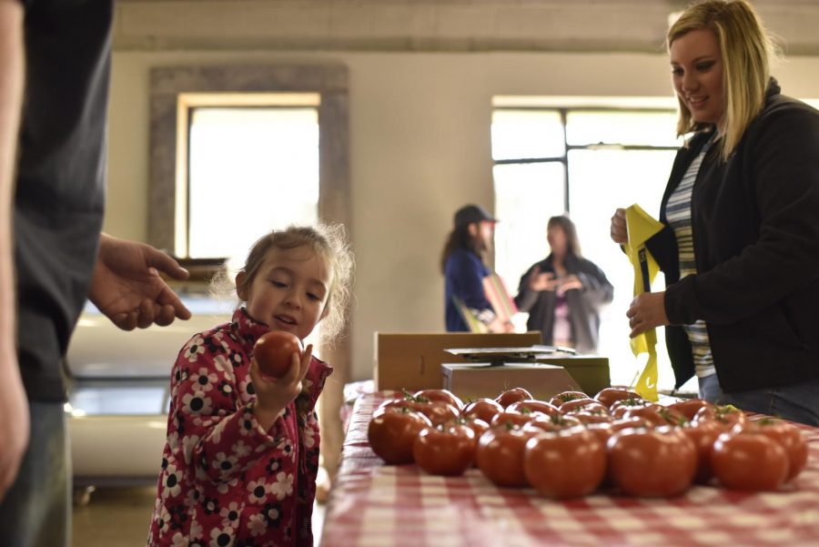 Haleigh Burton, 18, of Morgantown makes a sale to a young customer at the Community Farmer’s Market in Bowling Green on Saturday morning. Burton sells tomatoes for Cardwell Family Farms. Gabriel Scarlett/HERALD