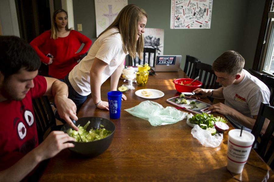 Paducah sophomore Maddison Beyer, third from left, admires Louisville sophomore Jonathon Blairs slicing skills while Burkesville junior Kurtis Spears, bottom left, dices lettuce for tacos for the $100 Solution Houses open house on Wednesday, April 13. JUSTIN GILLILAND/HERALD