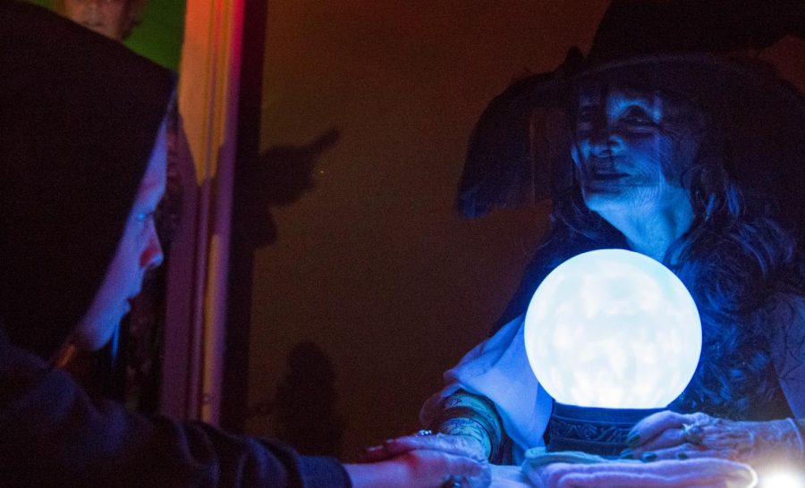 Meredith Thessen, right, takes part in the Victorian Halloween celebration as a fortune teller and palm reader Friday, Oct. 14, in Riverview at Hobson Grove. Tyger Williams/HERALD
