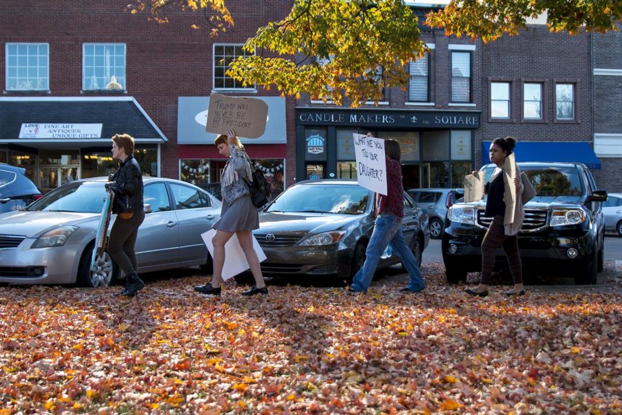 A group of protestors walk through Fountain Square Park in downtown Bowling Green holding up anti-Trump signs to passing cars and people in the area on Wednesday Nov. 9, 2016. ...Ive been told over and over that I need to love this country because Im from here, but its hard to when the country doesnt love you back, Bowling Green senior Briana Phillips said. Kathryn Ziesig/HERALD