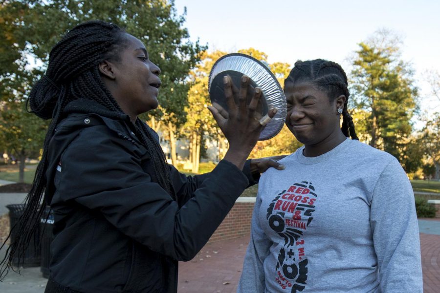 Itunu Francis, senior from Nigeria, takes a pie to the face from Louisville junior Sharon Brooks during Pie Face Day on Thursday, Nov. 10, at Centennial Mall. The event was hosted by Alpha Kappa Psi to raise money for their fraternity. Evan Boggs/HERALD