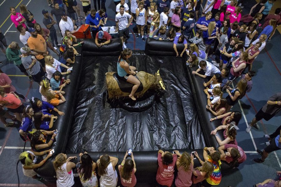 Participants gather around a bull riding simulator during the annual 12-hour dance marathon, Dance Big Red on Friday March 31 in Preston Fitness Center.