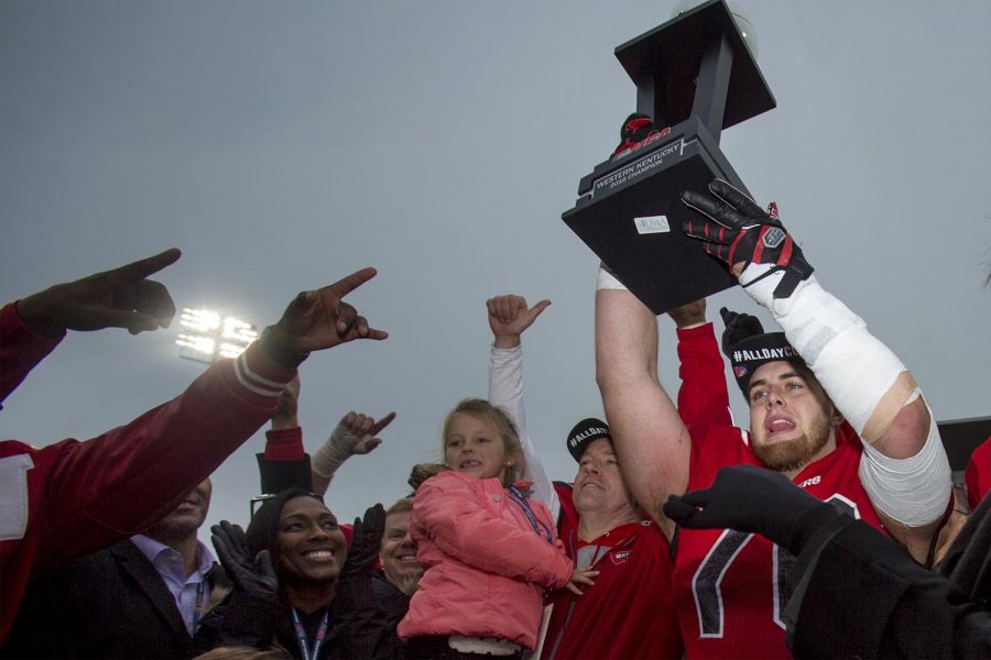 Western Kentucky offensive lineman Forrest Lamp (76) hoists the Conference USA trophy after the Hilltoppers defeated LA Tech to win their second conference championship on Dec. 3, 2016 at L. T. Smith Stadium.