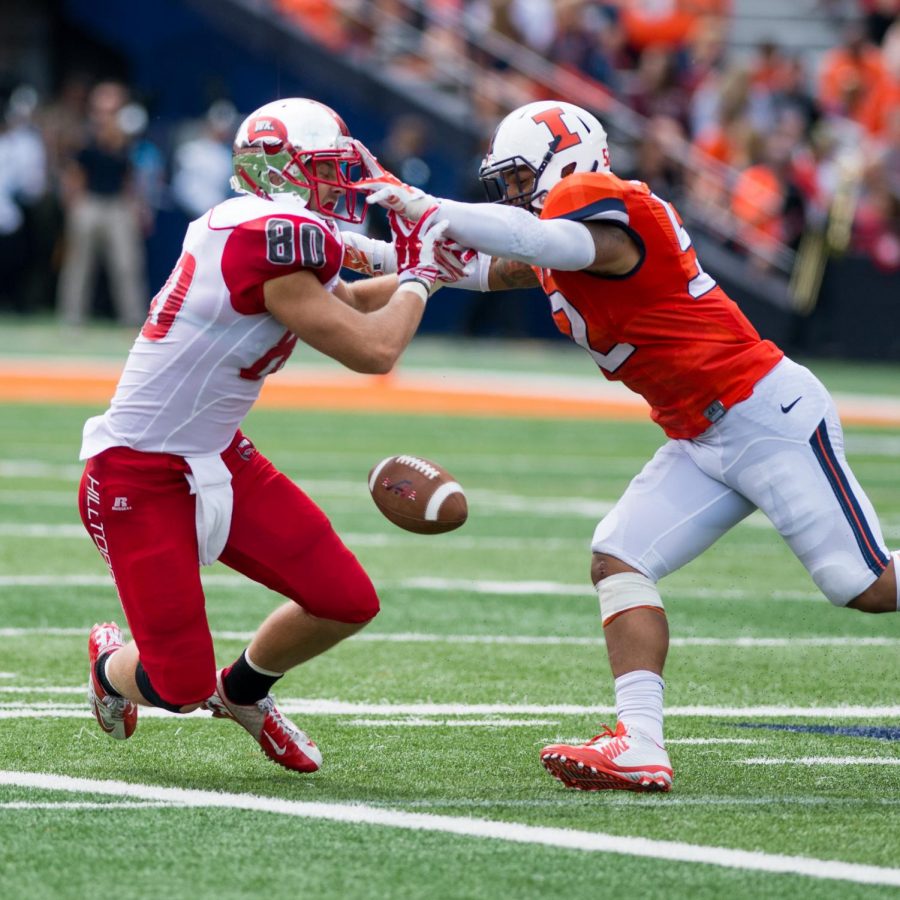 Senior tight end Mitchell Henry struggles with Illinois sophomore line backer T.J. Neal in the first half of the WKU vs Illinois game on Sept. 06, 2014 at Memorial Stadium in Champaign, Ill. Nick Wagner/HERALD