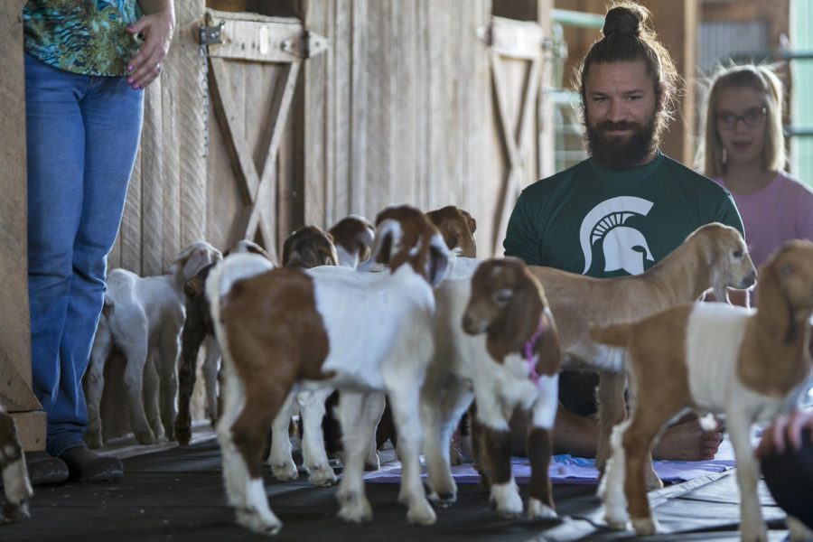 Nashville resident Nick Scholten watches as the baby goats are released from their pin into the yoga area during the Be Happy Baby Goat Yoga class on Sunday, Sept. 24 at Buck Creek Stables in Smiths Grove, Ky. Scholten attended the class with his girlfriend Emily Monroe, a Bowling Green resident, after he heard about it on Facebook.