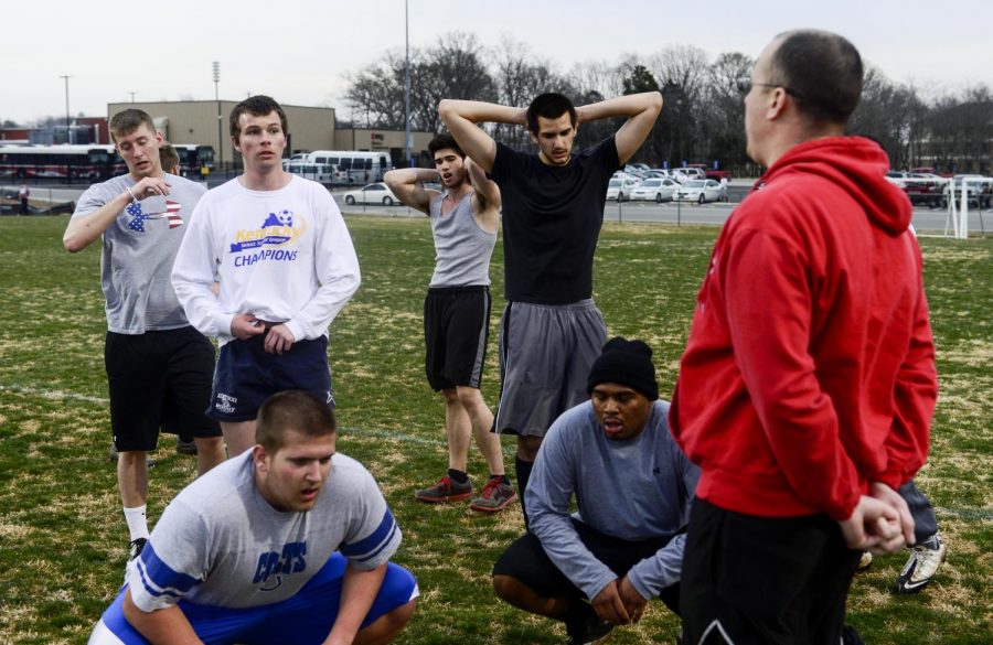 Members of the mens rugby team catch their breathe at doing a conditioning drill during a practice at the intramural fields. Joshua Ferriell (far right) coaches the team. (Ian Maule/HERALD)