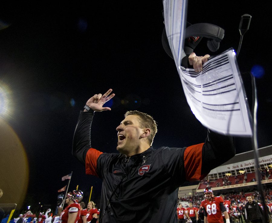 Head coach Mike Sanford cheers at WKU fans after kicked a win in triple overtime during WKUs game vs MTSU on Friday Nov. 17 in Houchens-Smith Stadium. WKU won 41-38.