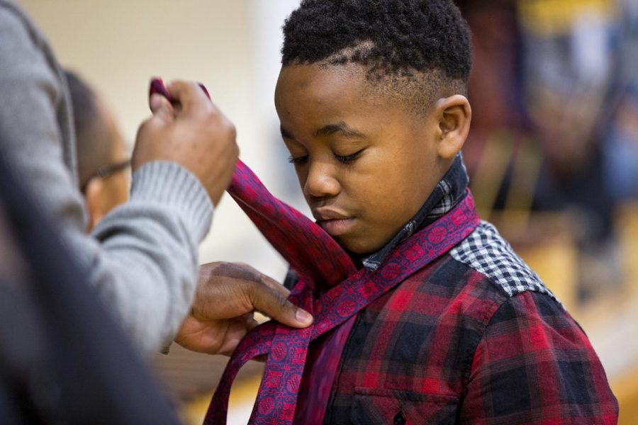 George Kibawa, 8, watches a volunteer work on his tie at Parker Bennet Curry Elementary School Friday, Feb. 2, 2018. The goal of the program is to motivate responsible behavior inside and outside of the classroom by giving them the incentive of wearing ties. The Boys 2 Men leadership program at Parker Bennet is headed by Tyreon Clark. If they look good, and feel good, they can behave good as well, he said.