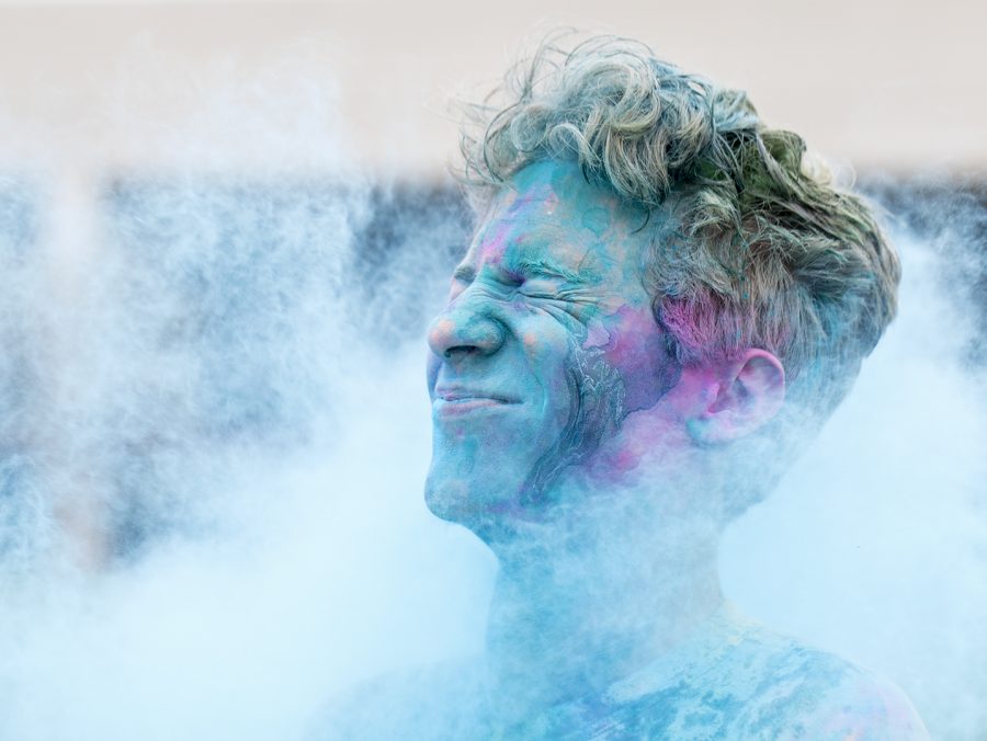 Conner Hounshell braces himself as a friend throws colored powered at him during Holi Festival which took place on South Lawn on Sunday. Holi is a celebration of spring and is known as the festival of color.
