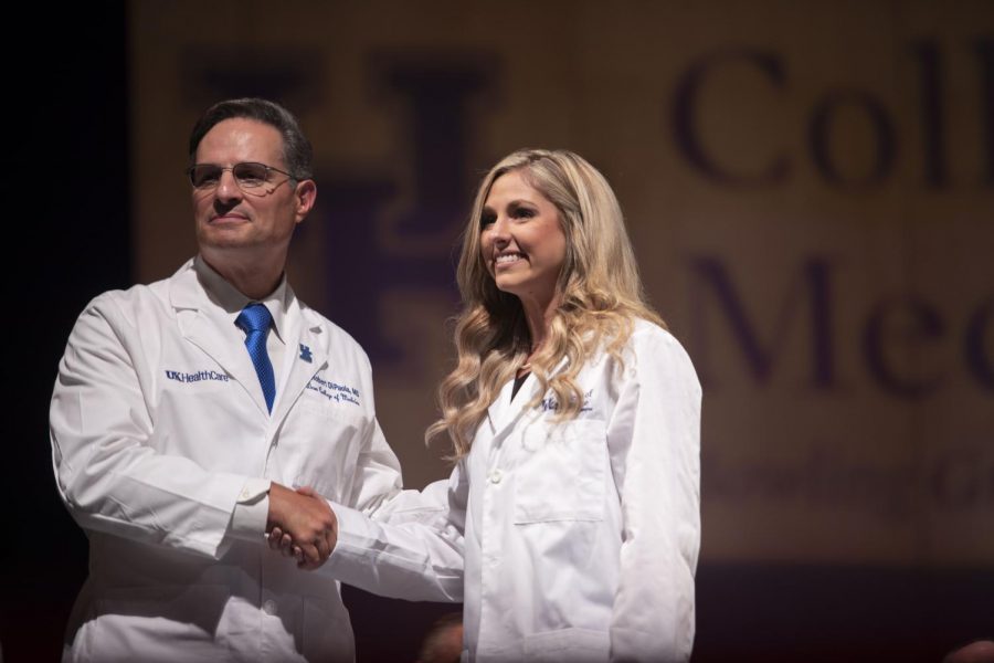 One female student from the inaugural class of the UK College of Medicine Bowling Green campus smiles for a photo on the stage of Van Meter Hall after putting on her white coat. The medical schools first white coat ceremony took place at Van Meter Hall on Friday.