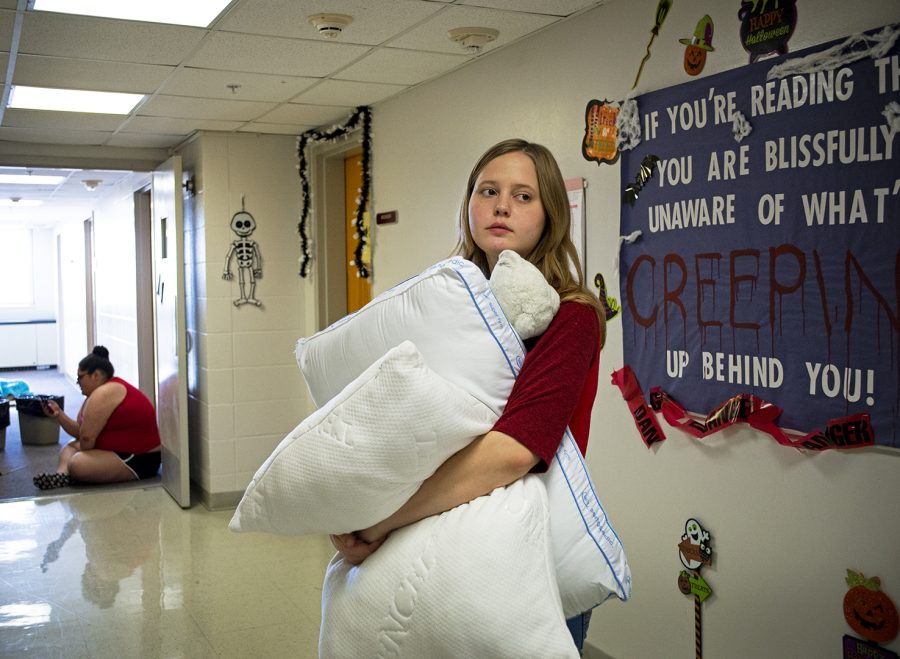 Lily Breitenstein, a freshman, carries her pillows and stuffed bear down to the laundry room of her new residence hall after having to move from Minton due to unsafe air quality. Lily was told to wash all clothing and bedding she owns while in Minton but states she, “didn’t have time to wash it all there.”