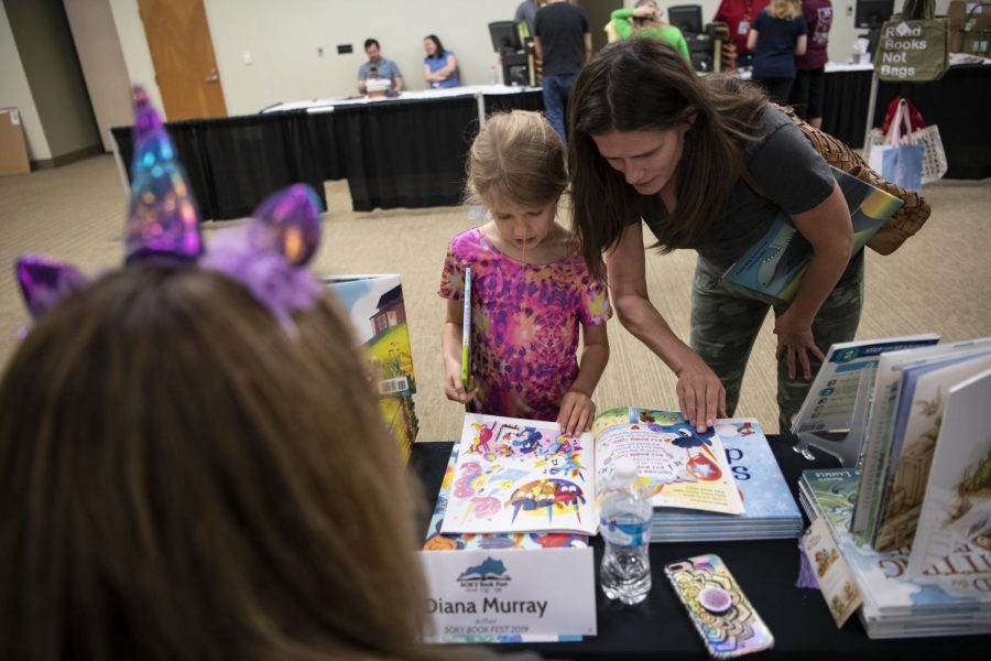 Isadora Treangen, 8, and her mom Victoria look at a book by Diana Murray during the SOKY Book Fest at the Knicely Conference Center on April 27, 2019. Stomp into reading, Murray wrote when she signed Treangens new book.