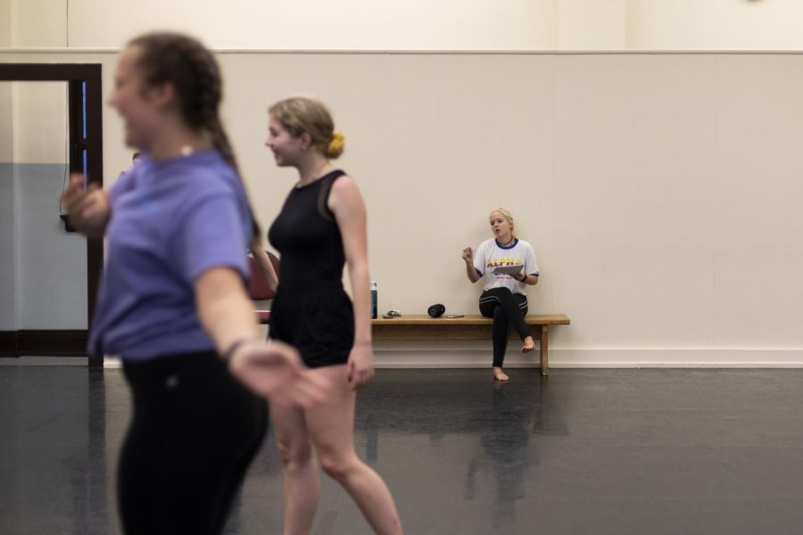 Heather Hartlage, choreographer for NDEO’s Kick the Clock, listens to the music and brainstorms ideas alone while her cast dances around her to the music in one of the dance studios in Gordon Wilson Hall of Friday evening, Sep. 6, 2019. Some of the dancers warm up quietly while others laugh and dance around with their friends.