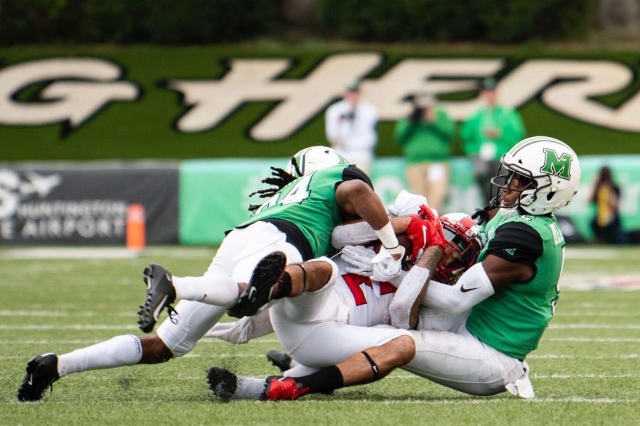 WKU wide receiver Jacquez Sloan (2) is brought down by Marshall’s Kereon Merrell (5) and Steven Gilmore (34) at Joan C. Edwards stadium on October 26, 2019 in Huntington, WV. WKU lost 26-23.