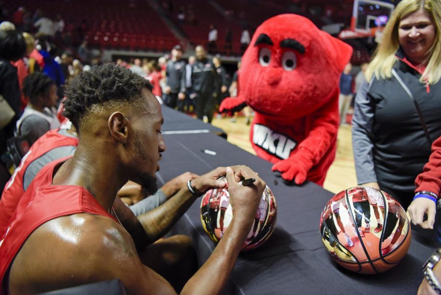 Josh Anderson(4) signs a fan made basketball after playing in scrimmage match on Thursday evening during the Hill Topper Hysteria event which offered appreciation to Hill Topper fans free autographs for all.