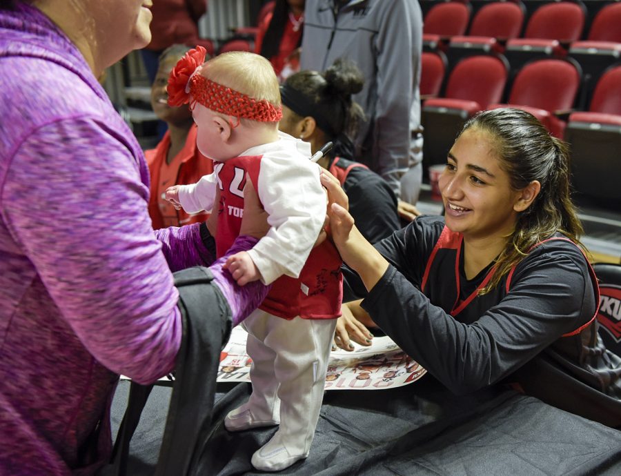 Meral Abdelgawad (40) signs the bib of 5 month old Piper Jensen after a scrimmage match in the annual Hill Topper Hysteria event. Jensen’s grandmother took her to the event saying, “We sign her shirt and get her young.”