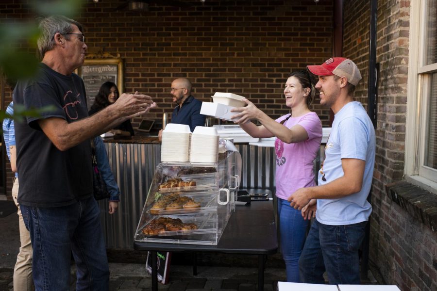 Nina (middle) and Kyle Pollock, the couple behind Park Street Doughnuts, hand their customers doughnuts at their pop-up shop on Sunday, Oct. 27, 2019, at Spencer’s Coffee. The up-and-coming doughnut shop consistently has lines out the door at each event.