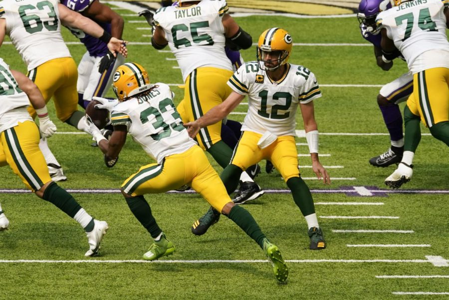 Green Bay Packers quarterback Aaron Rodgers (12) hands the ball off to running back Aaron Jones (33) during the first half of an NFL football game against the Minnesota Vikings, Sunday, Sept. 13, 2020, in Minneapolis. 