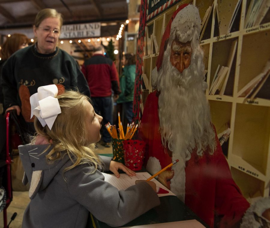 Linley Boykin, 5, stops to write a Christmas list to Santa with her grandmother and great-grandmother on Saturday, Nov. 9, 2019, at the GypsyMoon Marketplace, which hosted a Christmas market weekend.