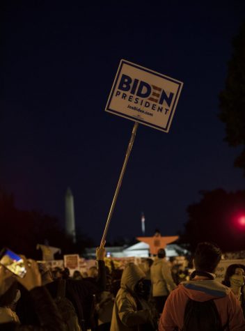 A person holds Biden presidential campaign signage outside of the White House on the night of election day, November 3, 2020.