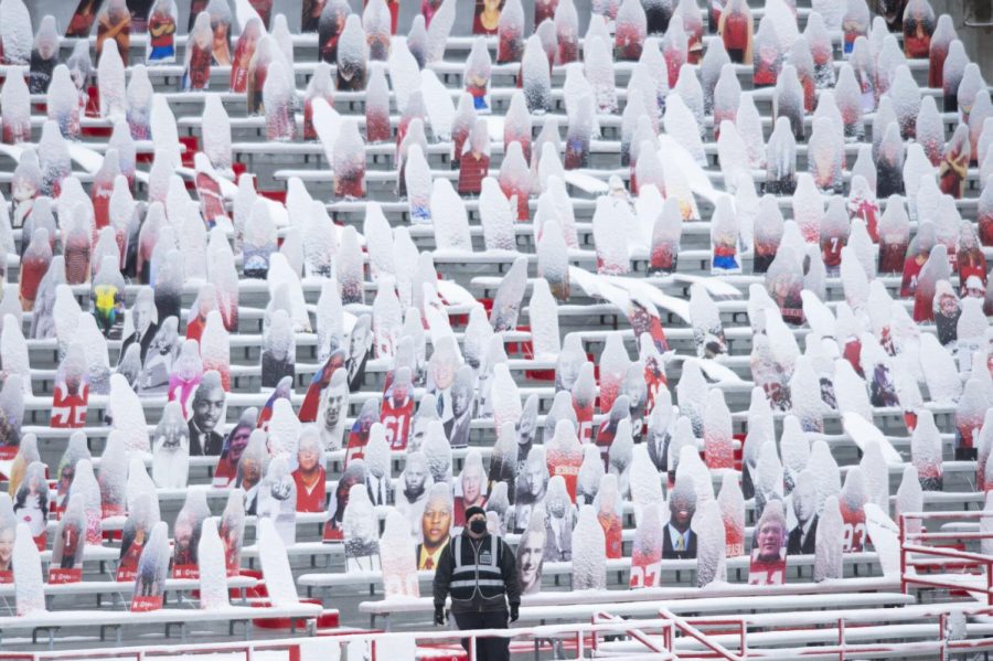 A+security+guard+watches+the+field+among+snow-covered+cardboard+cutouts+before+a+Nebraska-Minnesota+football+game+on+Dec.+12%2C+2020%2C+at+Memorial+Stadium.