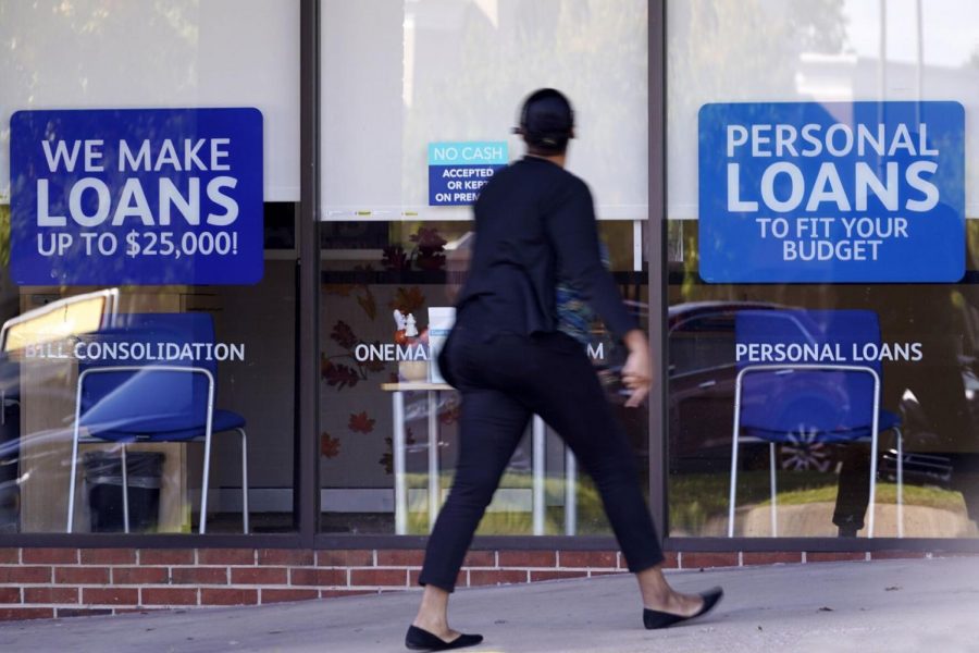 A woman walks past a personal finance loan office Thursday, Oct. 1, 2020, in Franklin, Tenn.