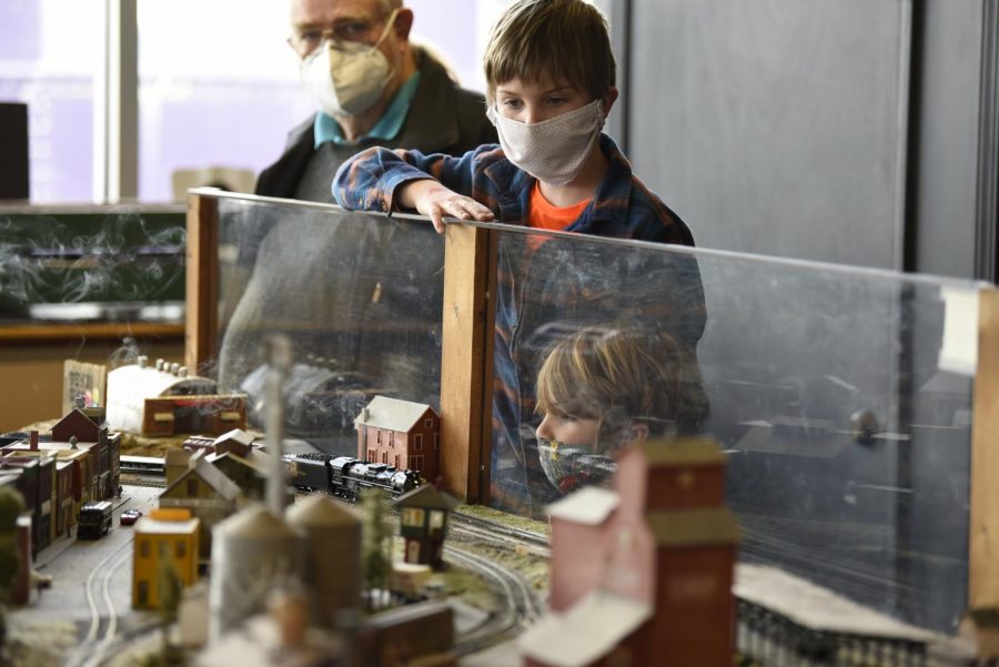 Brothers Ephraim (center) and Anselm Krans watch as a model train drives past them at the Historic RailPark and Train Museum in Bowling Green. The museum hosted a model train show on Saturday, March 6, 2021.