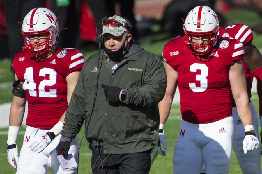 Nebraska assistant coach Mike Dawson walks back to the sideline flanked by Nick Henrich (left) and Will Honas in November at Memorial Stadium.