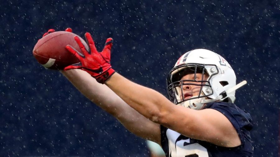 Tight end Jack Koceman reaches out to bring in a catch as the rain falls on the first day of spring practice for the University of Arizona, Tucson, Ariz., March 23, 2021.